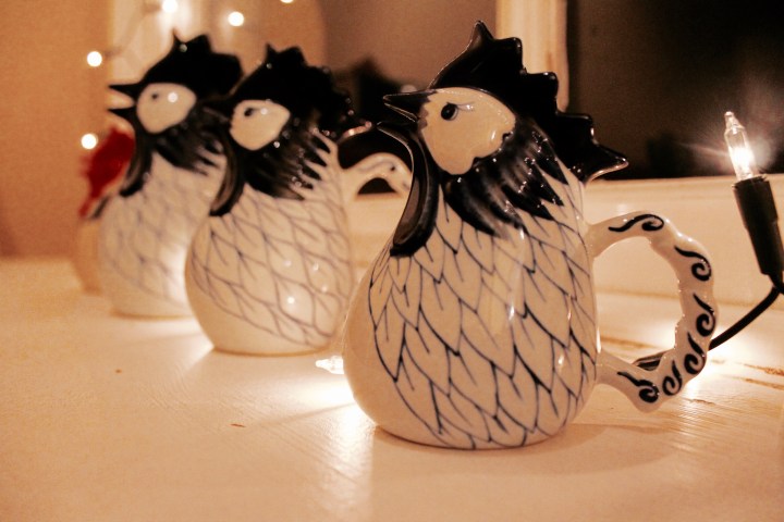Chicken jugs on a window sill surrounded by glowing fairy lights