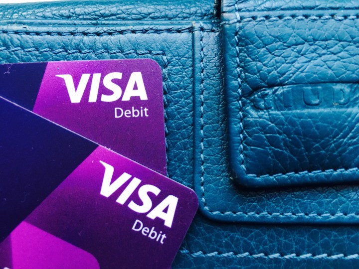 Visa cards sitting on top of a ladies wallet