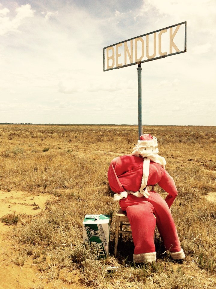 Santa Clause mannequin sitting beside a property name sign in western New South Wales, Australia