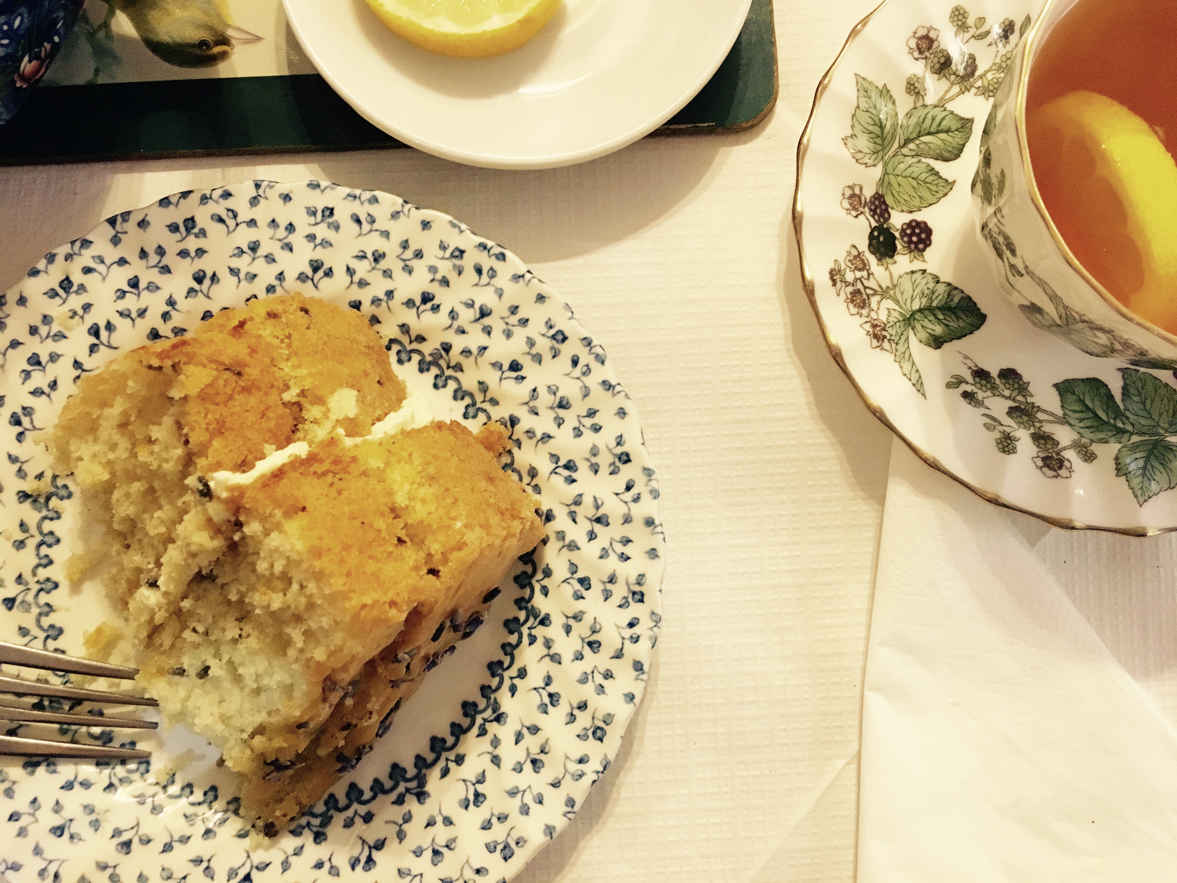 Orange and lavender cake and earl grey tea with lemon served on mismatched, vintage porcelain