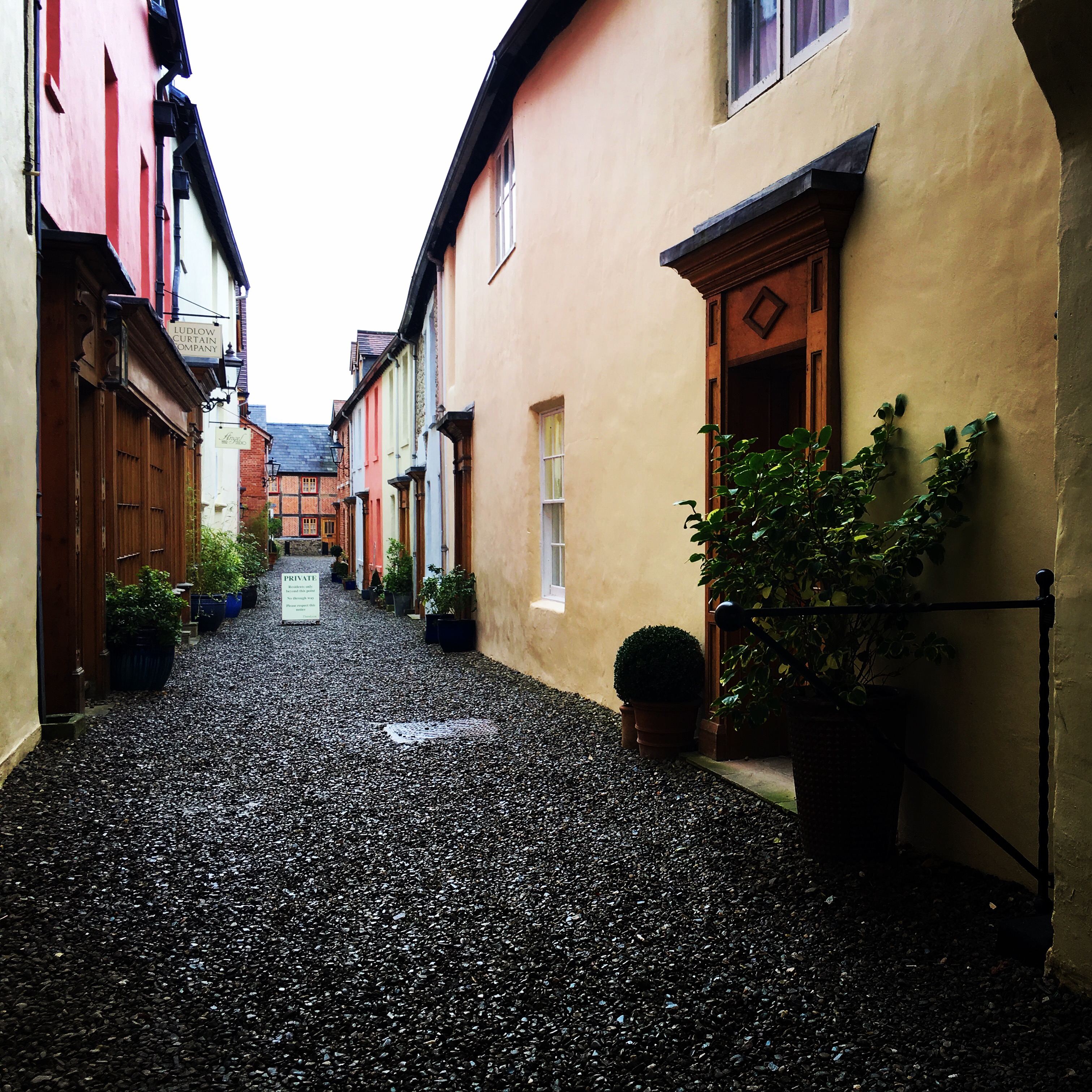 A private laneway filled with rainbow coloured cottages in Ludlow, Shropshire