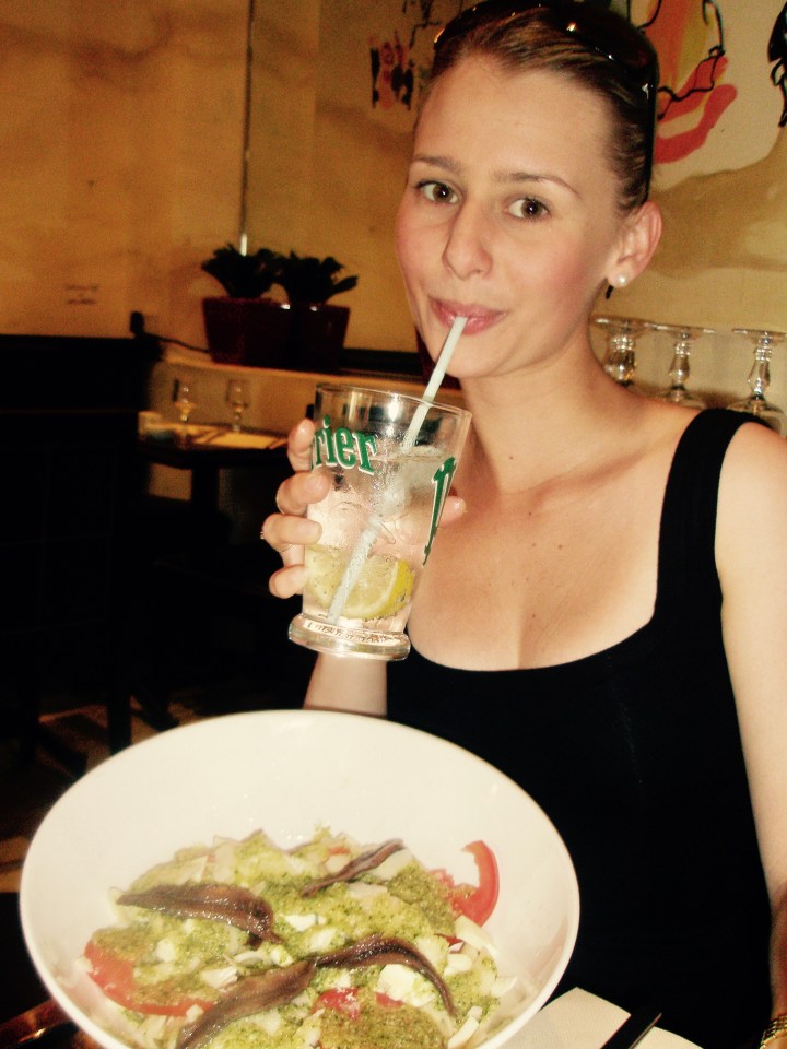 Women with bowl of pasta at bistro in Paris.