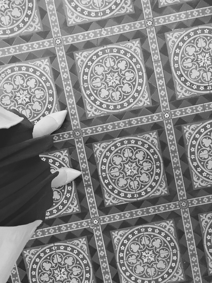 Feet on intricately tiled floor.