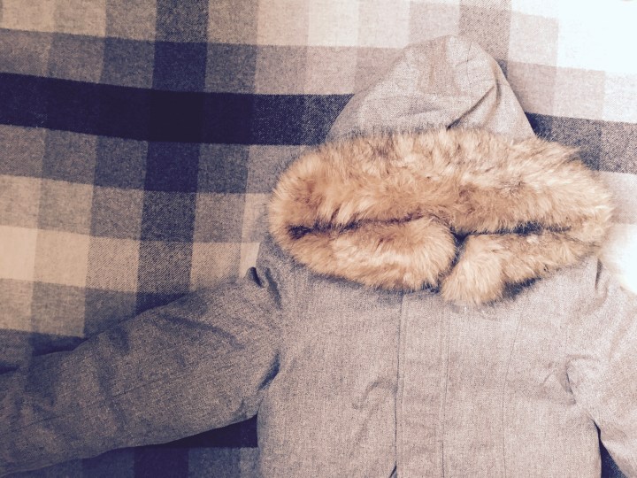 Flat lay of winter coat with fur hood.