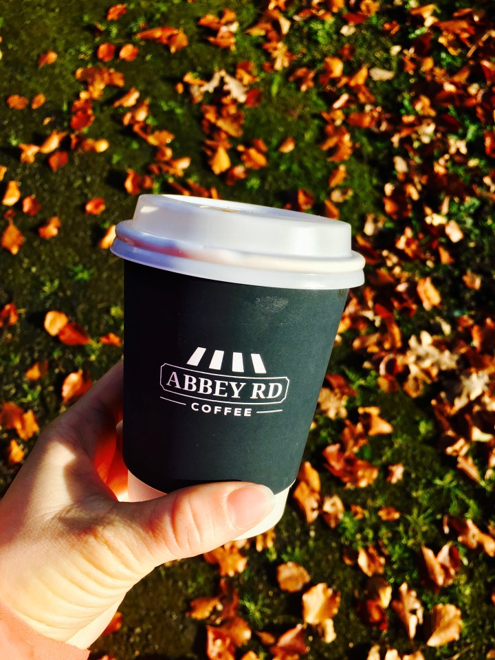 Hand holding takeaway coffee cup.