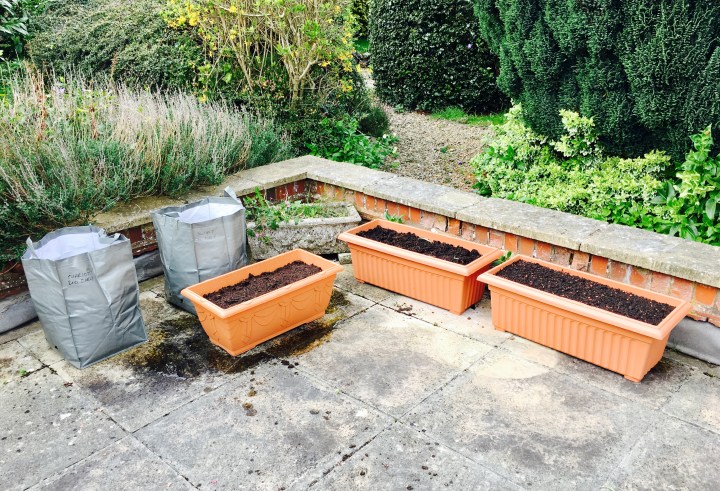 Terrace with planter bags and tubs full of soil.