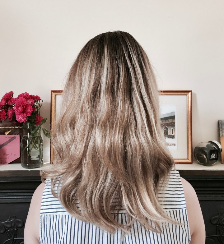 Back of woman's head standing in front of mantle piece.