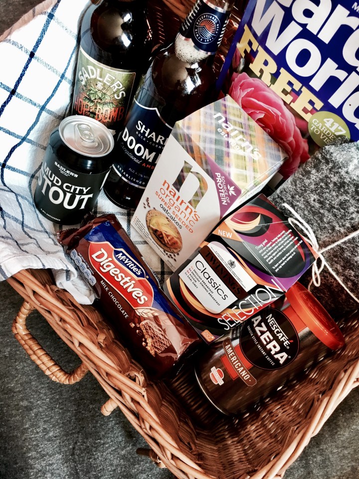 Wicker picnic basket full of tea, coffee, biscuits, beer and presents.
