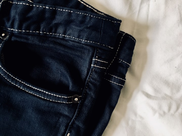 Flat lay of dark indigo pair of jeans.