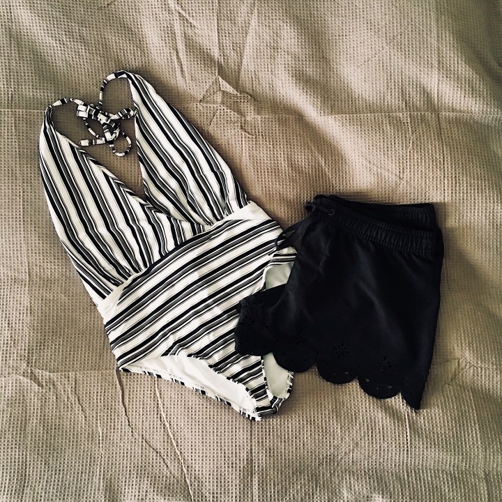 Black and white striped one piece swimsuit and black board shorts.