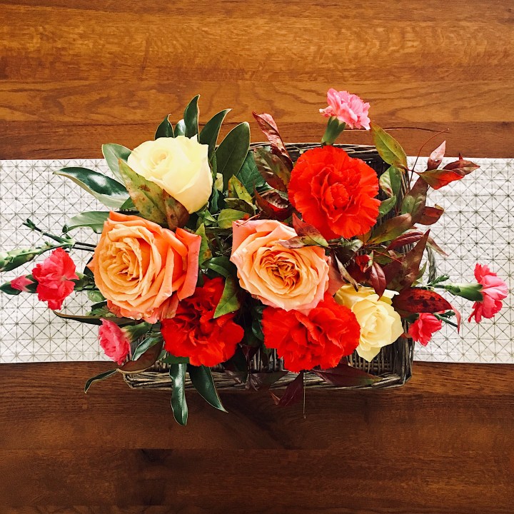 Looking down on a bunch of peach, yellow, red and pink flowers.