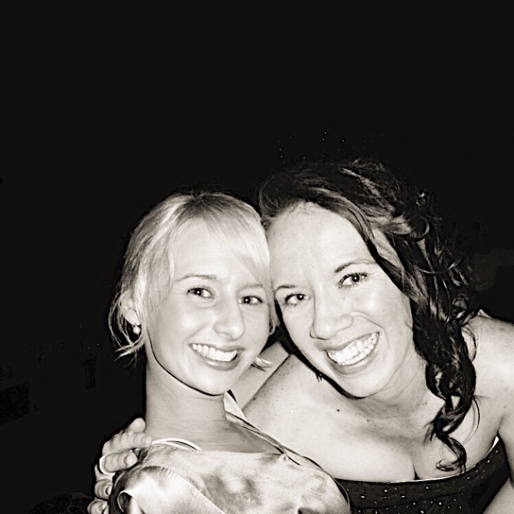 Two young woman smiling in a black and white photograph.
