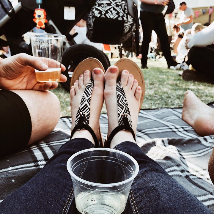 Feet on a picnic blanket at the Gears and Beers festival in Wagga Wagga, New South Wales, Australia.