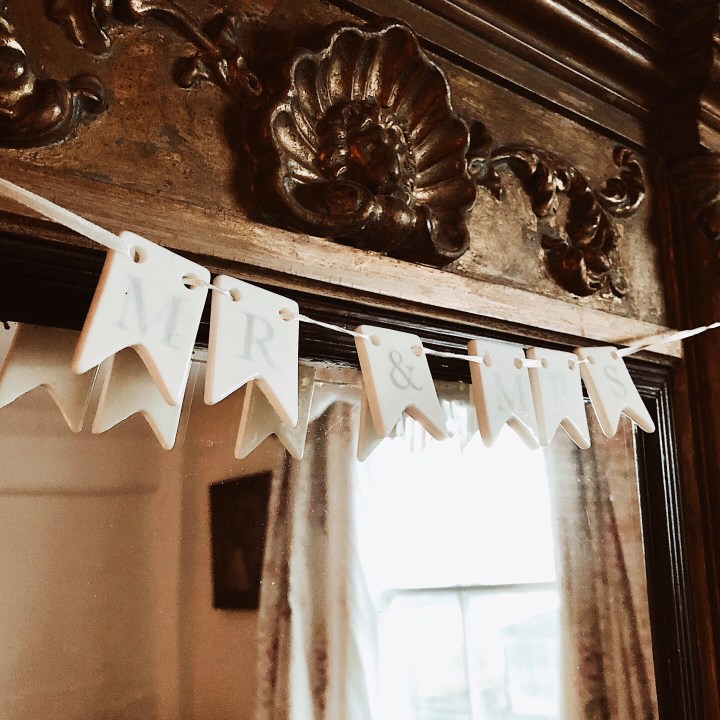 Ceramic bunting hanging above a mirror, spelling out Mr and Mrs.