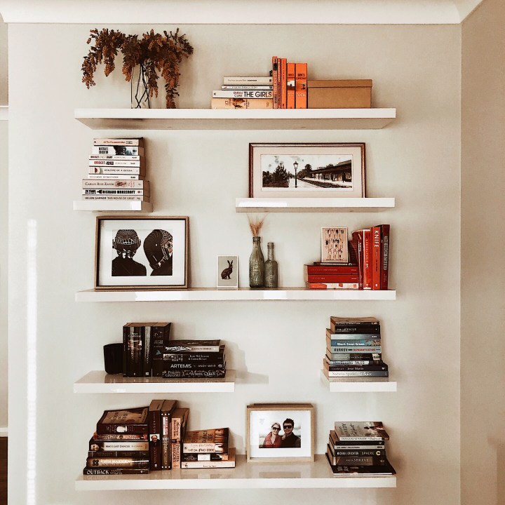 Bookshelves filled with flowers, artwork, postcards, photos and knick knacks.
