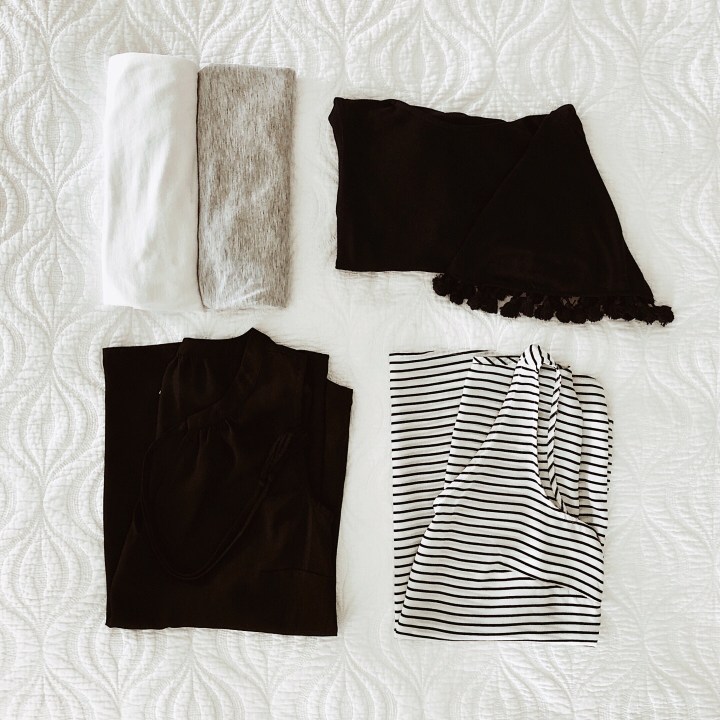 Flat lay of black, white, grey and navy tops.