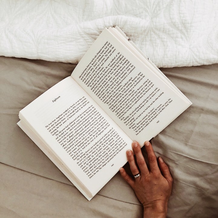Woman's hand holding an open book.