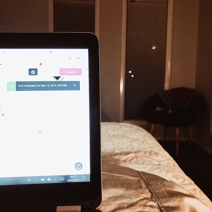 Laptop screen in dark bedroom.