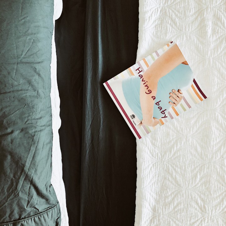 NSW Health baby book sitting on a bed.