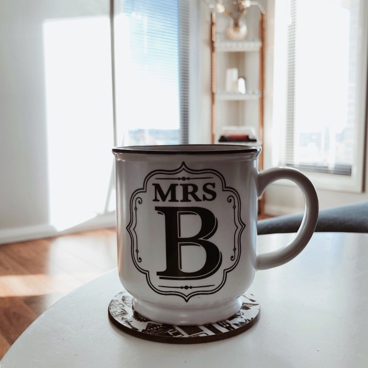 A mug of tea sitting on a table in a bright lounge room.