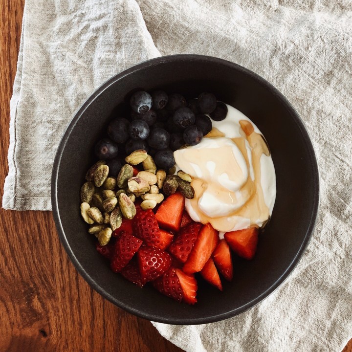 Greek yoghurt with blueberries, strawberries, pistachios and honey.