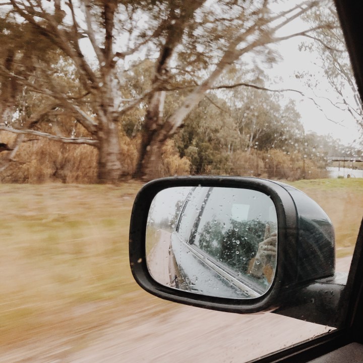 Looking out of a car window at a rainy landscape.