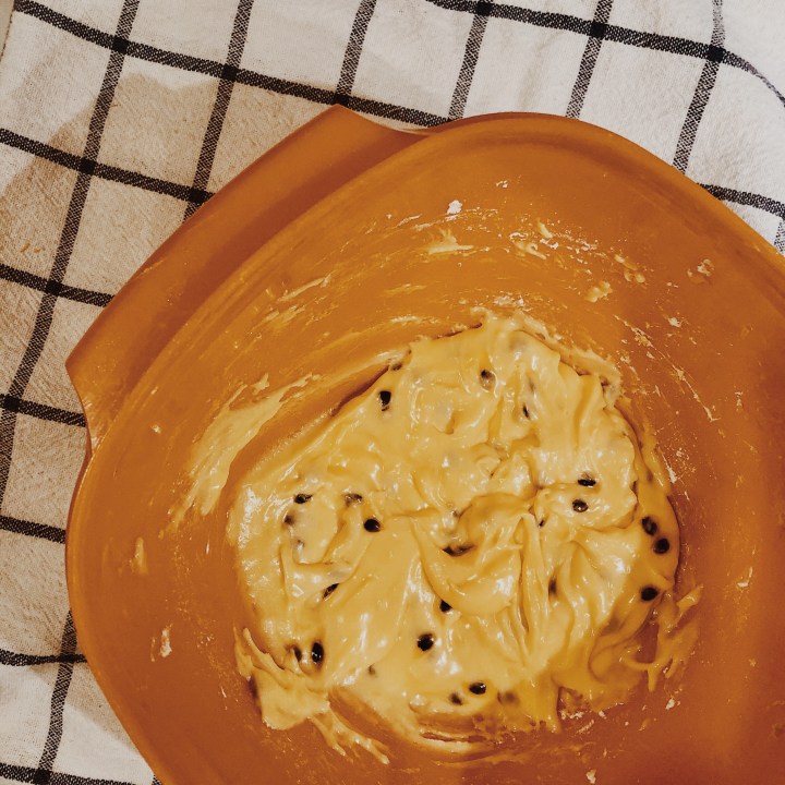 Passion fruit icing in a Tupperware bowl.