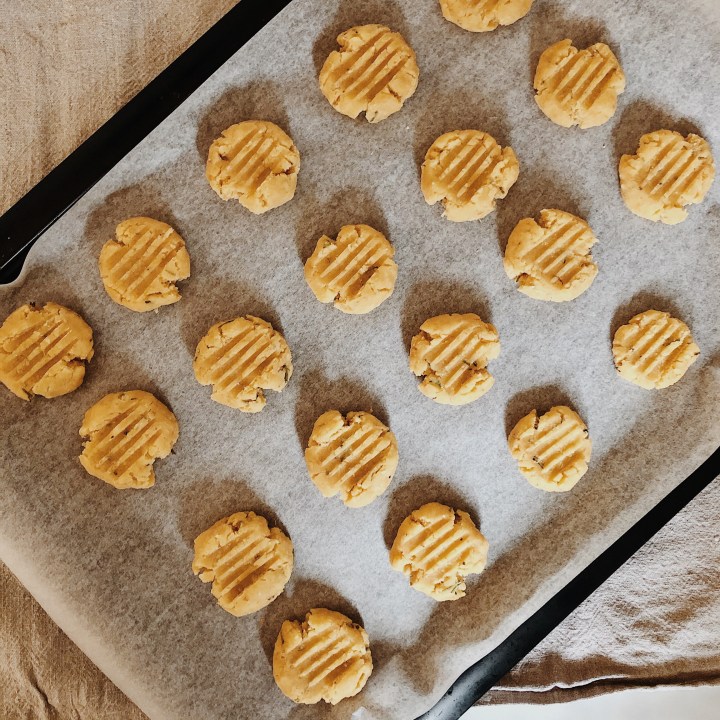 Parmesan and rosemary biscuits on a baking tray ready to go in the oven.