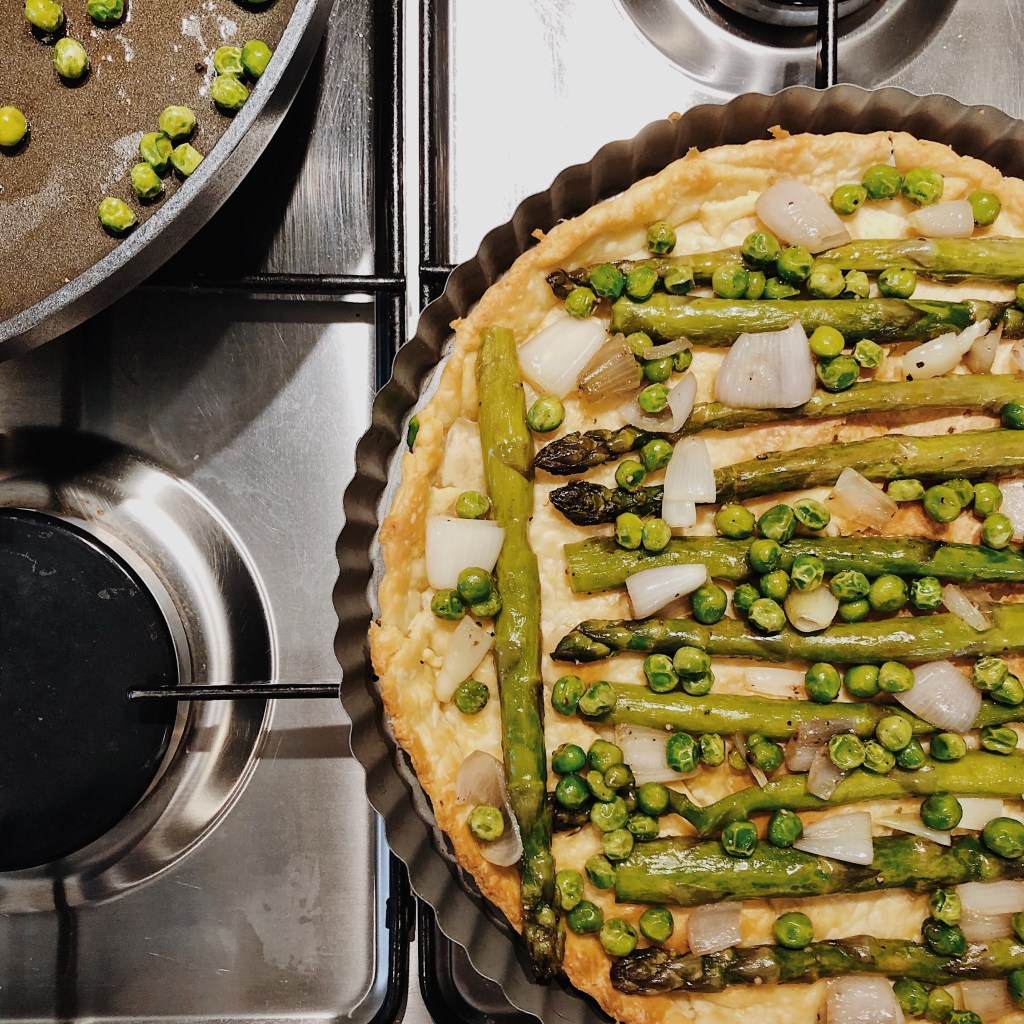 Vegetables laid out on a short crust pastry tart shell.