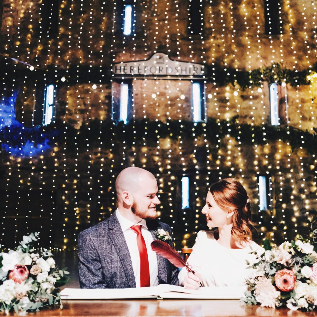 Couple sign wedding registry at Lyde Court, Hereford, United Kingdom.