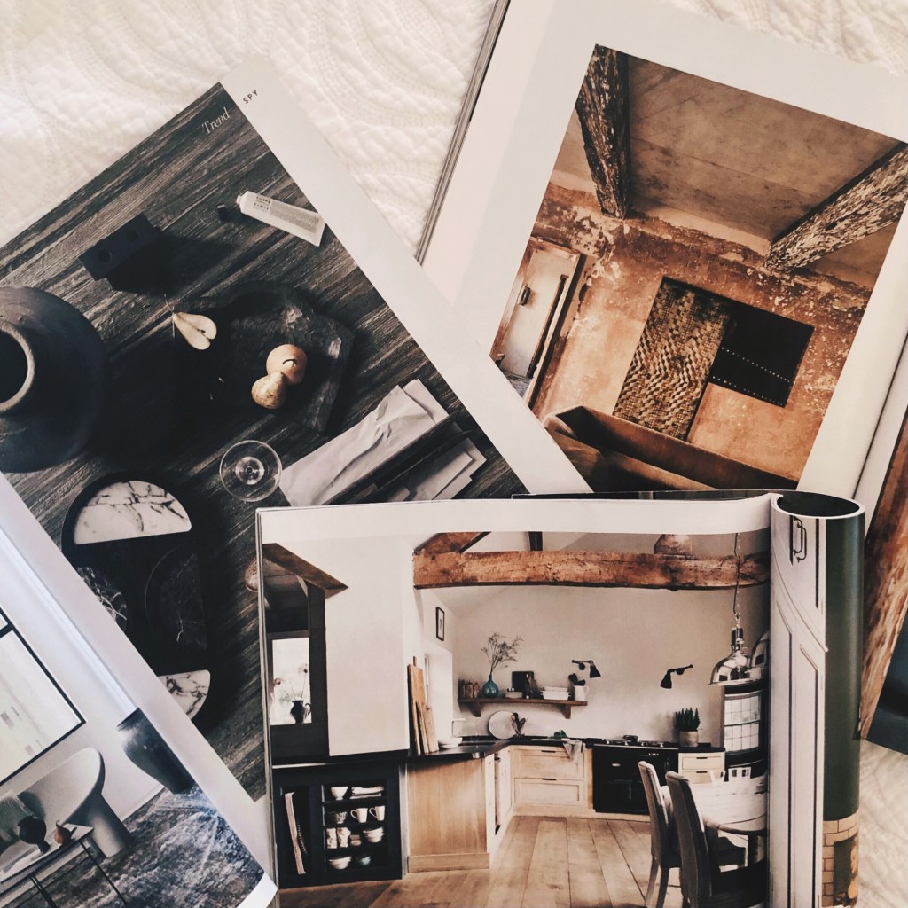 Open magazines scattered on a white bedspread.