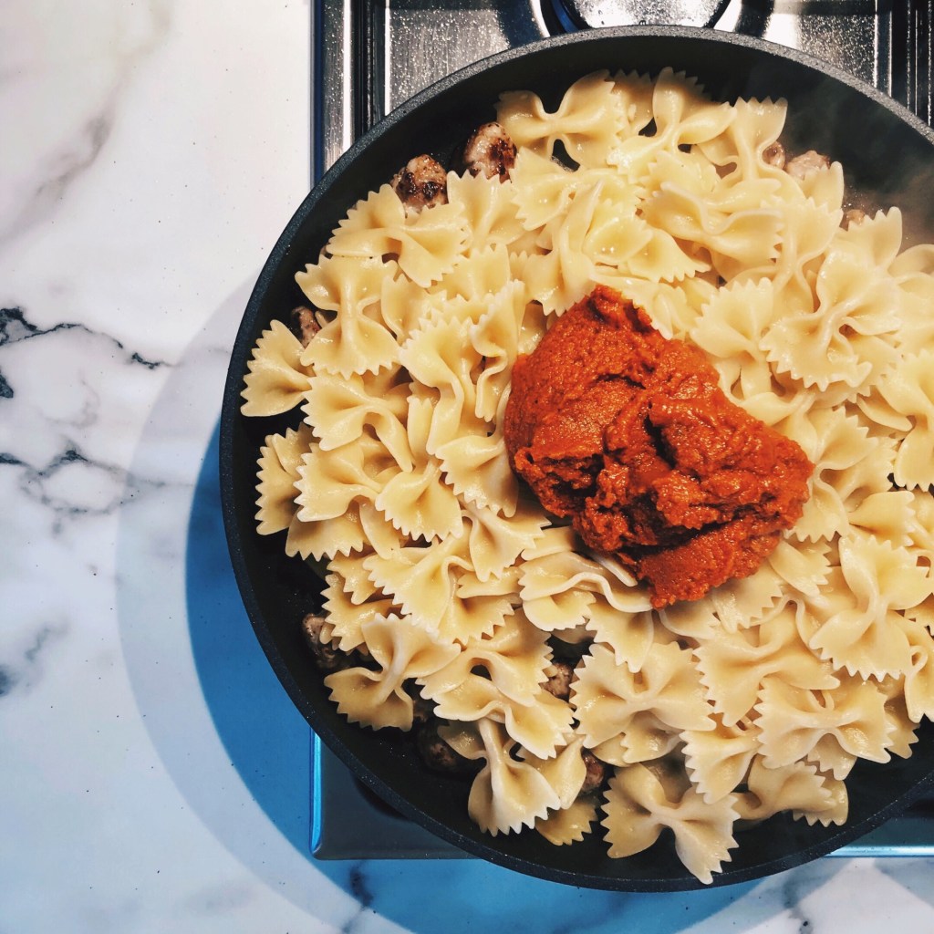 Pasta and pesto in a large fry pan.
