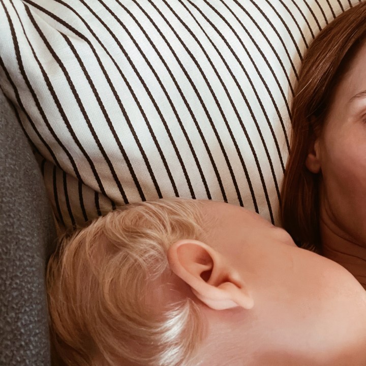 Obscured picture of a mother with a sleeping child on her chest.